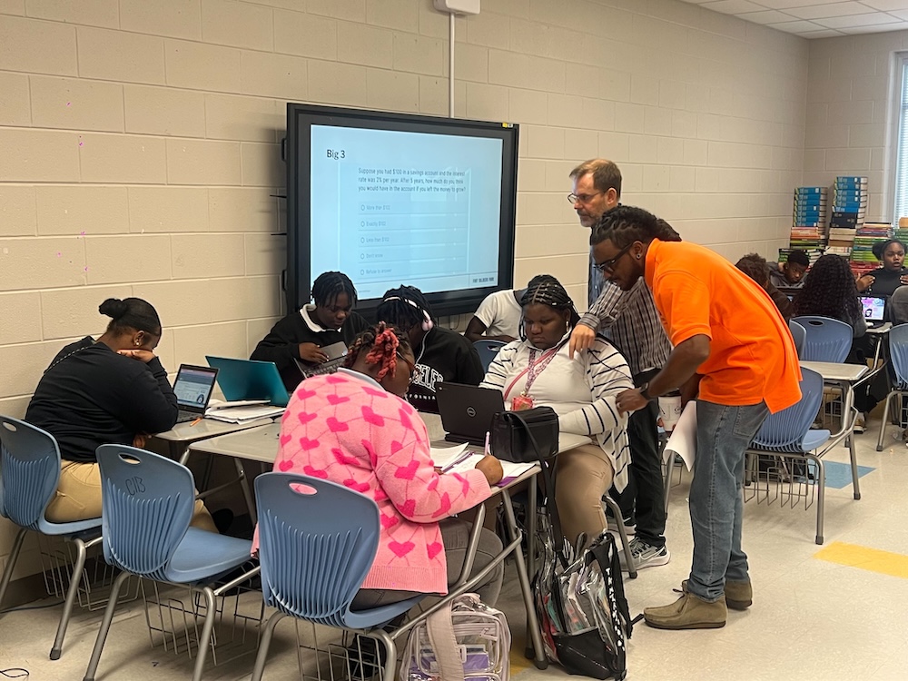 Teachers working with students in a group setting.