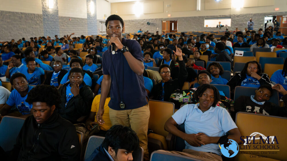 Student in audience holding microphone during Foot Soldiers Park financial literacy program Build Up